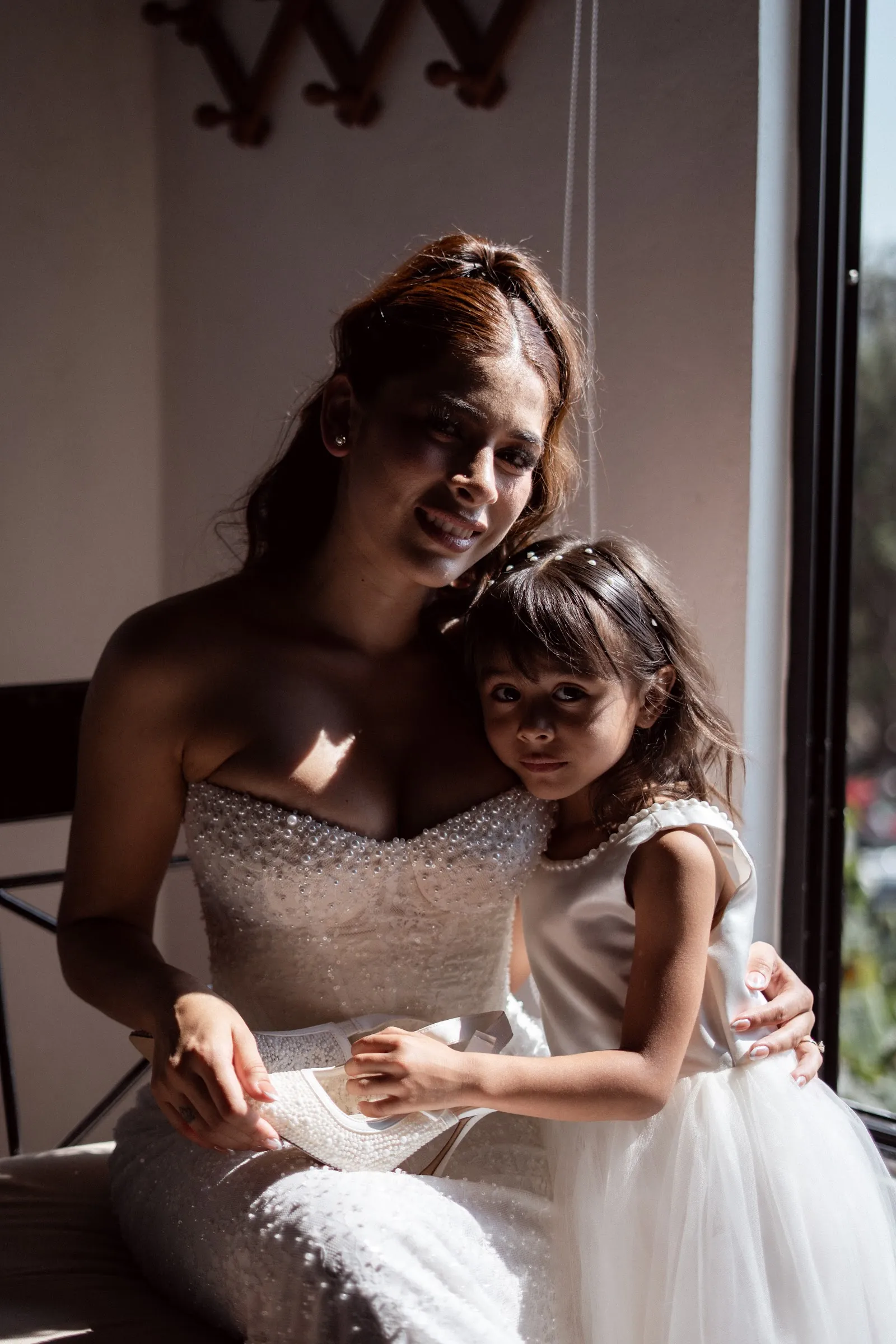 La novia abrazando a una niña