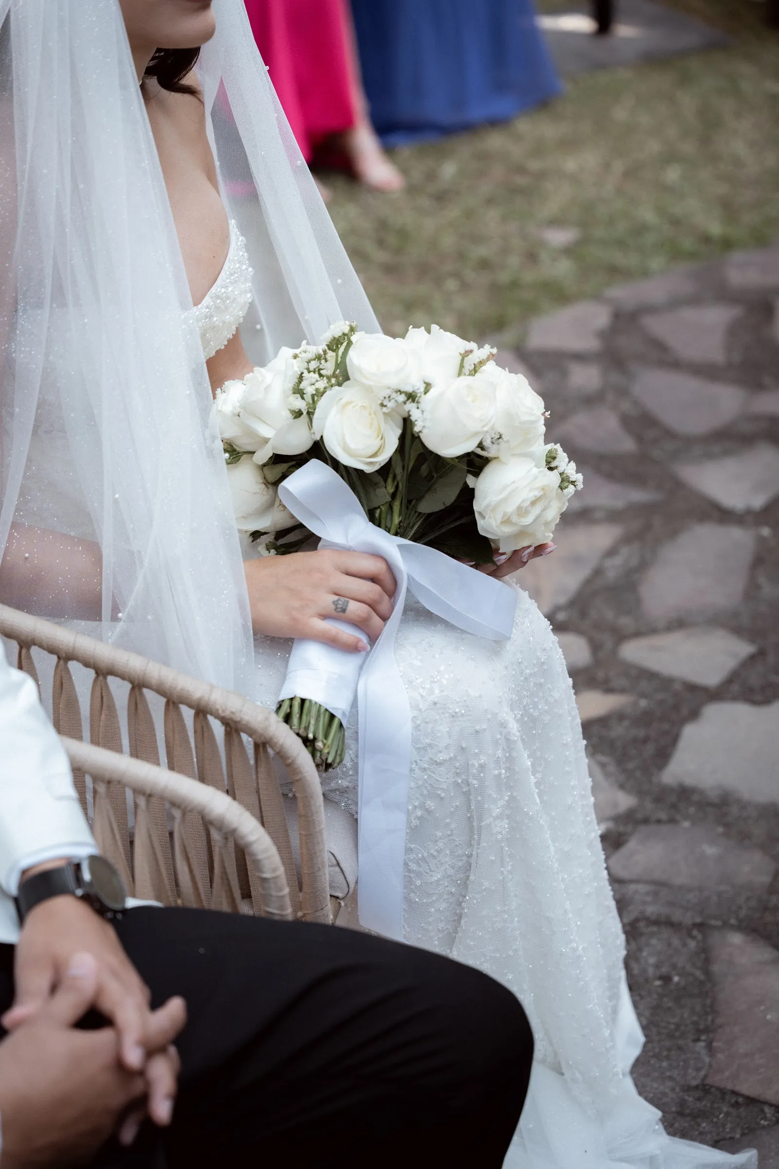 La novia sentada; detalle del vestido y el ramo