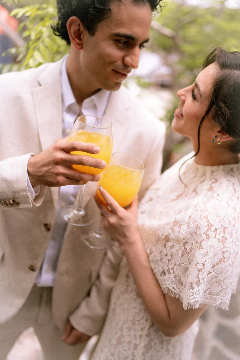 Gus y Karla brindan con jugo de naranja mirándose a los ojos