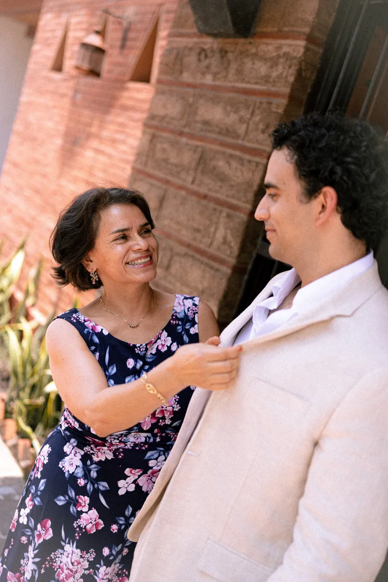 La madre del novio le acomoda el saco mirándolo a los ojos antes de la ceremonia