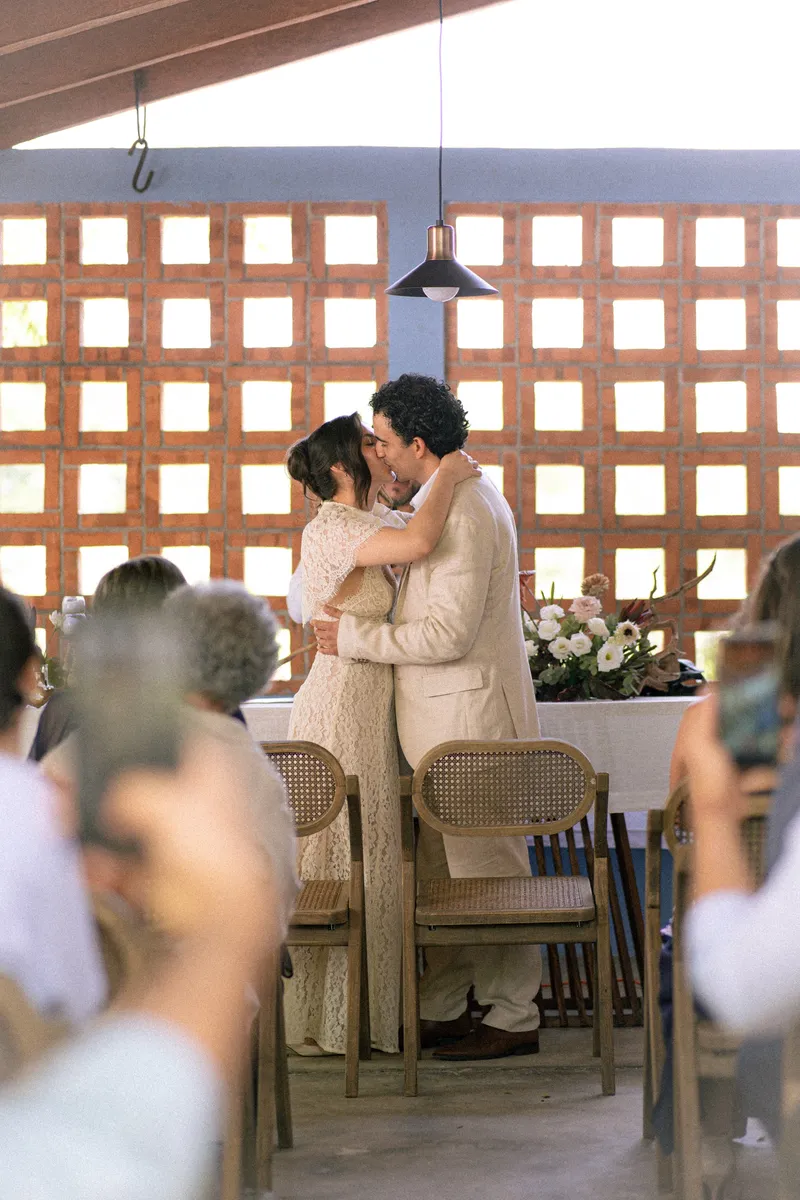 Gus y Karla se besan en el altar, enmarcados por la celosía de ladrillo