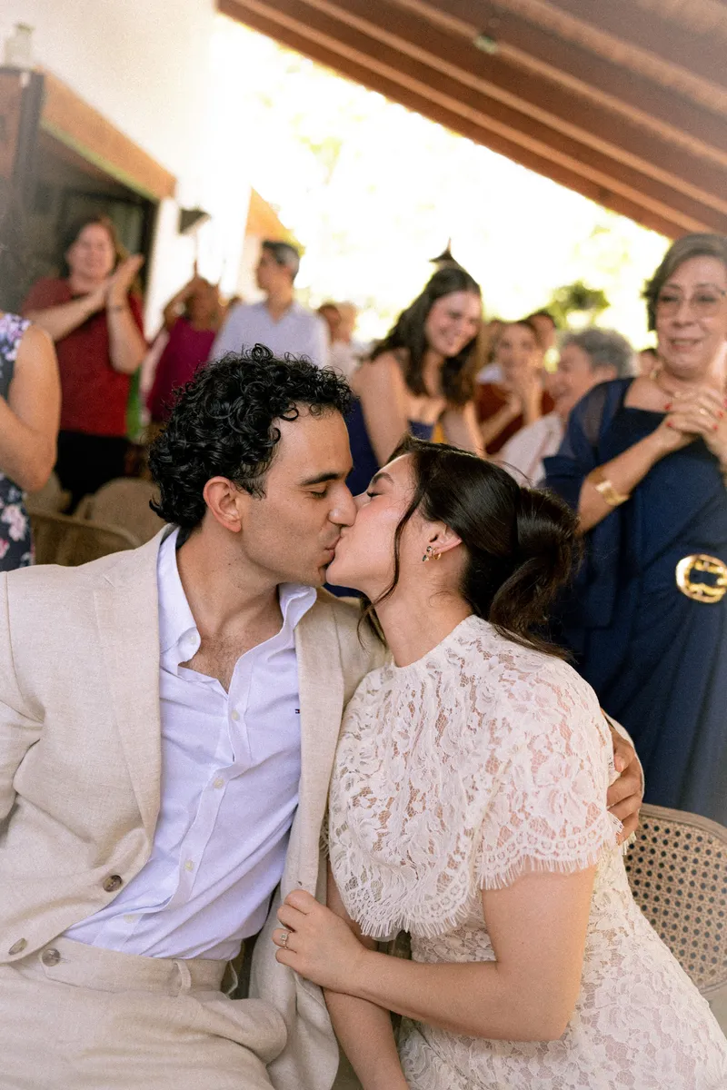 Gus y Karla se besan en la mesa mientras los invitados aplauden de pie