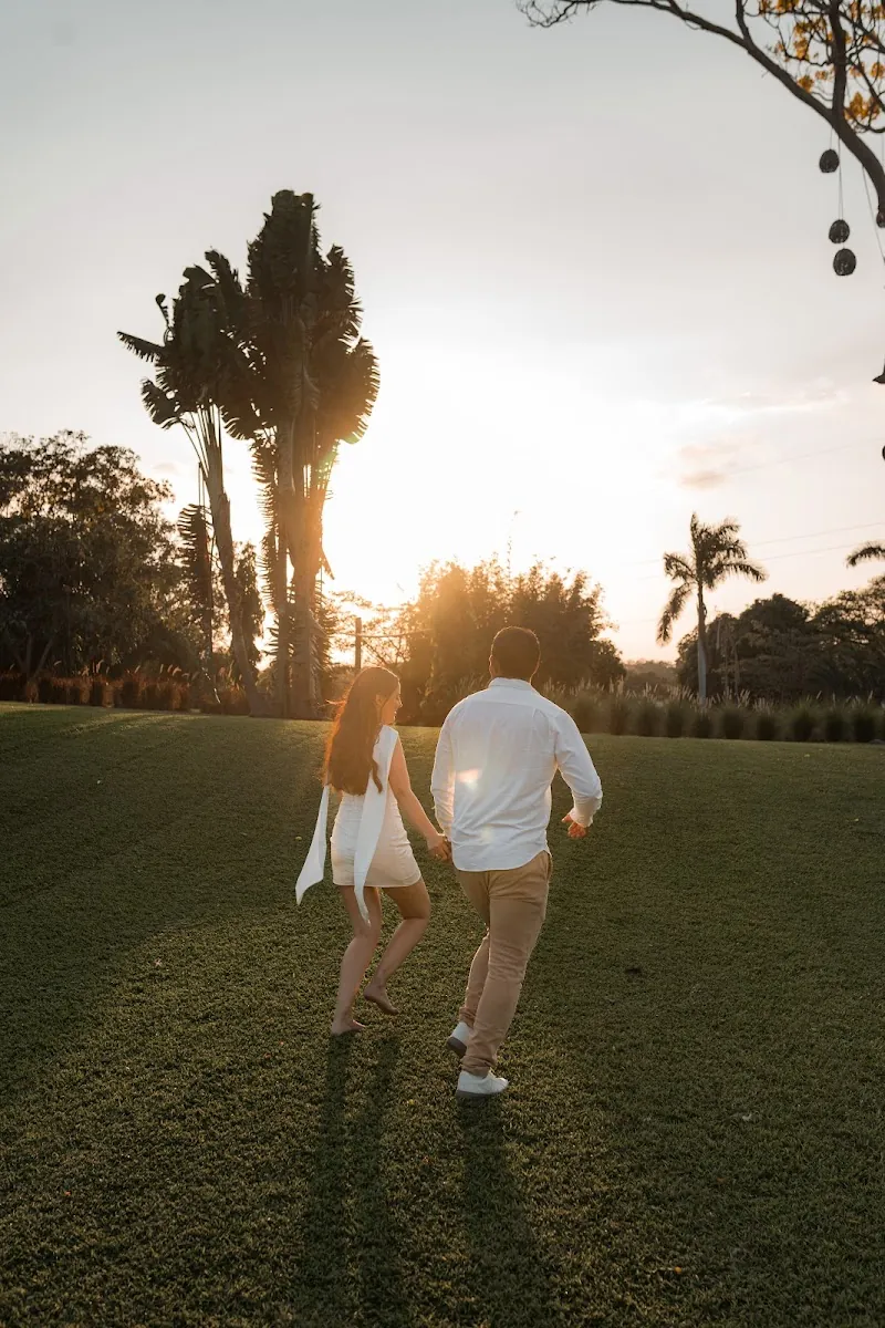 Pareja caminando de la mano al atardecer, luz dorada