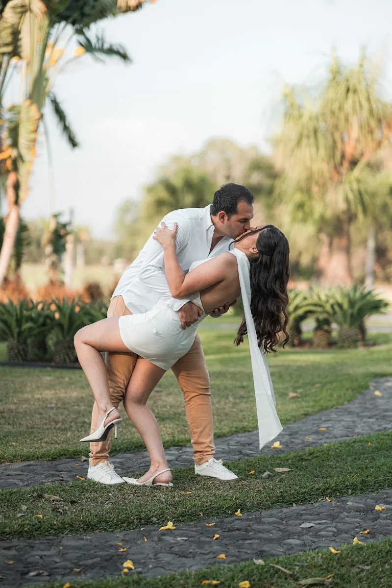 Paola y Carlos en un beso inclinado en el jardín a la hora dorada