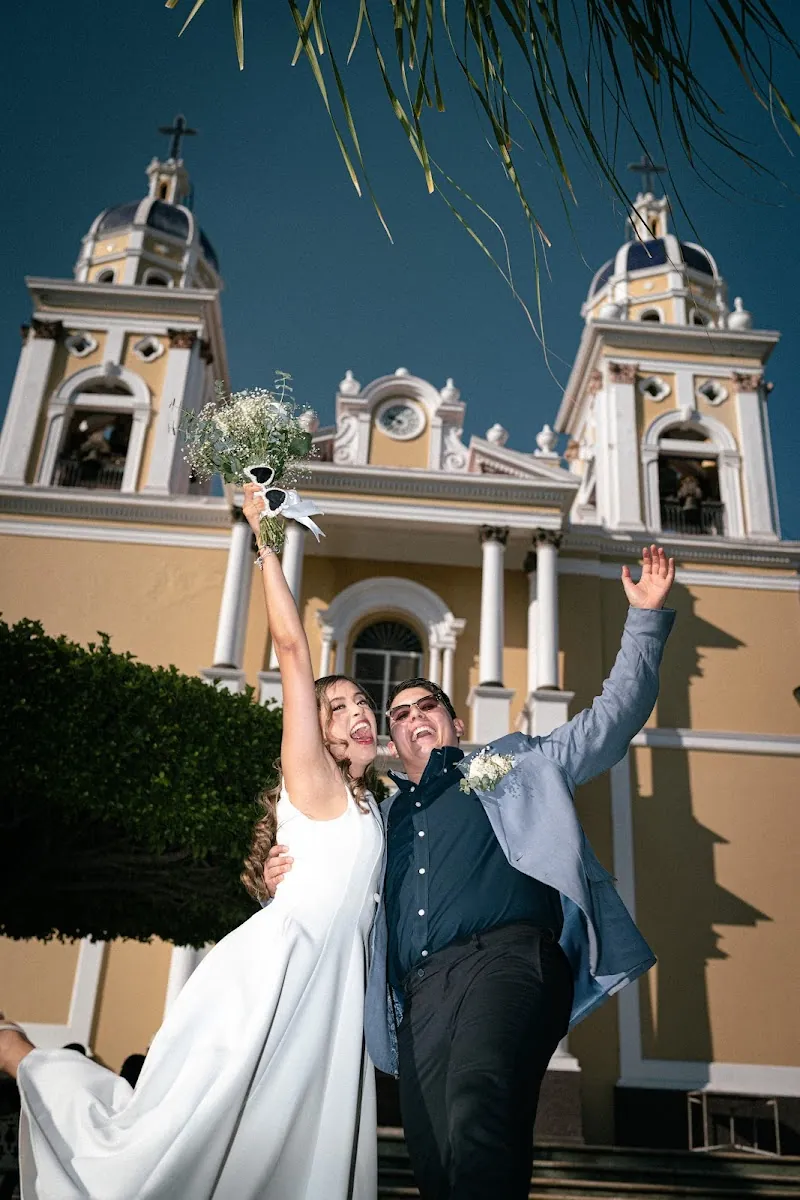 Ricky, Sofi y sus invitados celebrando con los brazos arriba frente a la parroquia