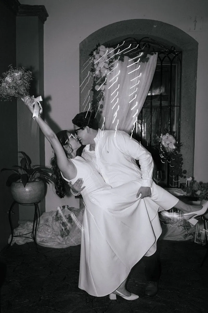 Beso de la pareja entre serpentinas, fotografía en blanco y negro