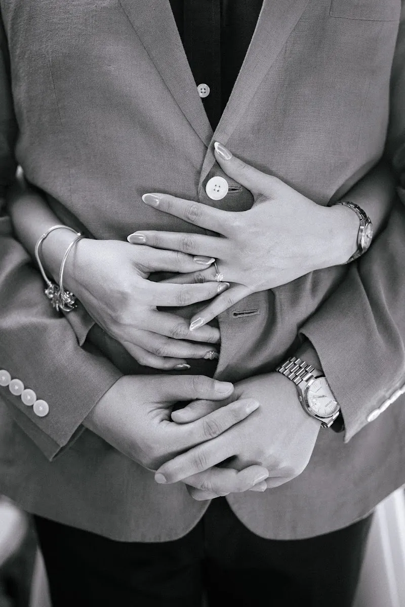 Manos de Ricky y Sofi entrelazadas, detalle en blanco y negro