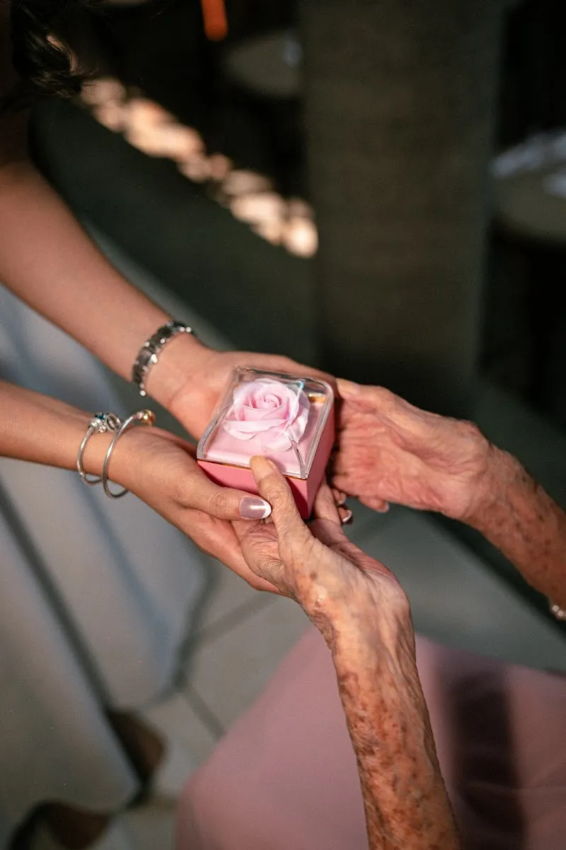 Manos de la abuela entregando un objeto a la pareja, detalle